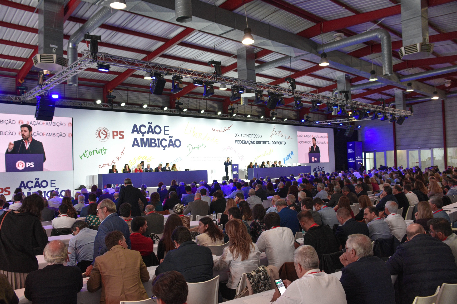 Vista ampla do congresso com sala cheia e plenário em sessão.